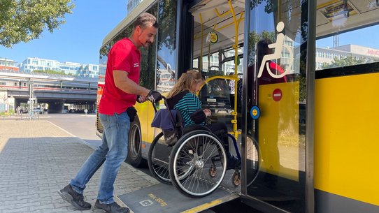 Der VBB Bus & Bahn Begleitservice hilft einer Rollstuhlfahrerin in den Bus