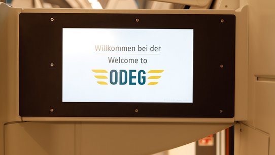 Das Foto zeigt einen Monitor im Zug, der Fahrgastinformationen anzeigen wird.