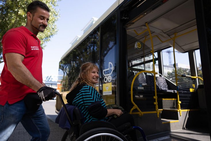 Unterstützung für mobilitätseingeschränkte Person bei ihrer Reise mit Bus und Bahn