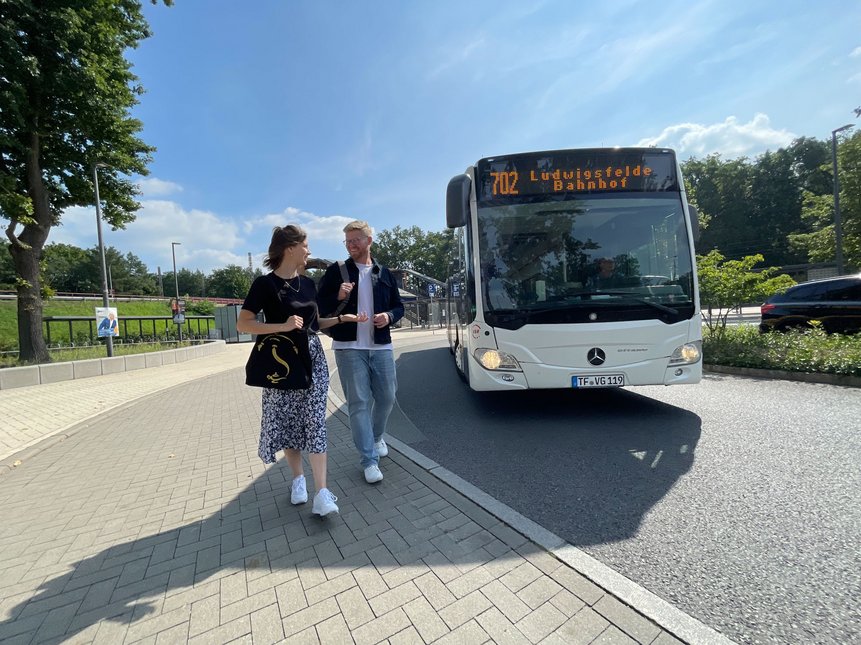 Eine Frau und ein Mann stehen neben einem Bus